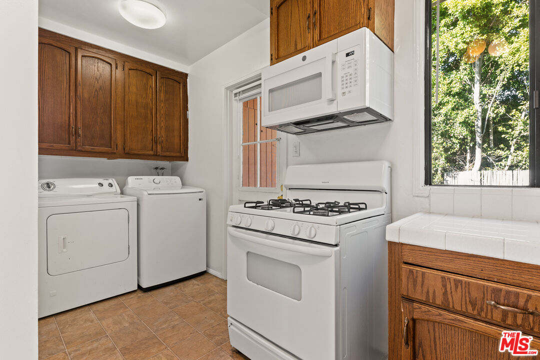 8710 El Manor Avenue, Unit 1 Los Angeles, CA 90045 - Photo 4 of 12 a kitchen with white cabinets and white appliances