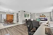 a living room with furniture and a dining table with wooden floor