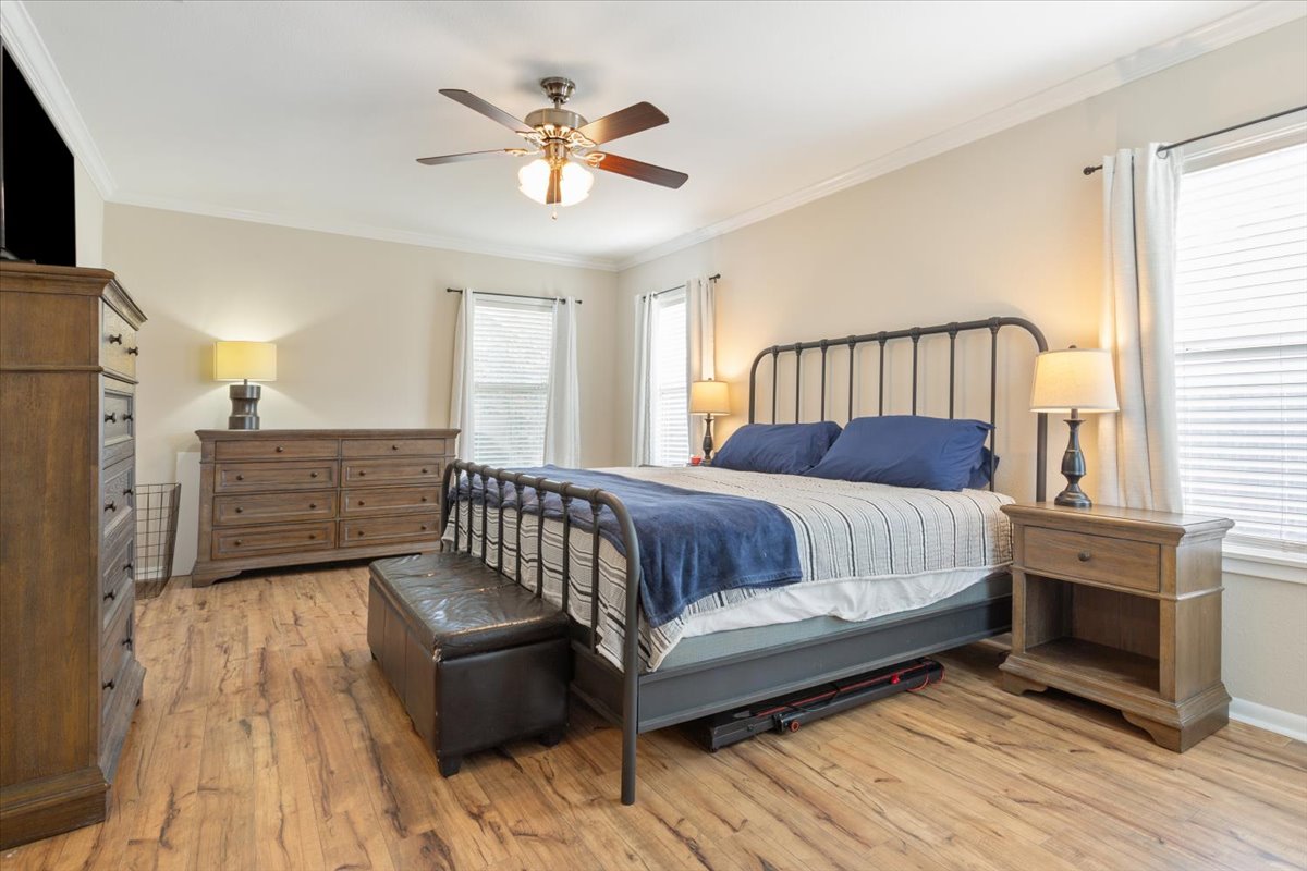1607 North Harding Avenue Cameron, TX 76520 - Photo 16 of 37 An inviting bedroom features rich hardwood flooring and a stylish ceiling fan for comfort.