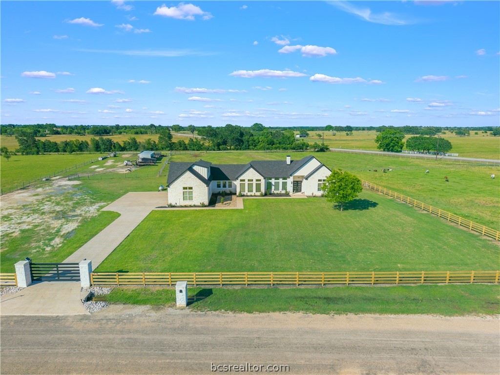 13504 Hudson Farms Road Hearne, TX 77859 - Photo 30 of 48 Your new land is a blank canvas with perimeter fencing and cross fenced. A place for horses or luxury hobby farming. Room for a massive pool oasis without the worry of trees or clearing expenses. Everything has already been done for you. From the moment you pass through the solar-powered security gate, the park-like 6.701 acres captivate. Inside, the home boasts soaring 14-to-16-foot ceilings and massive windows that flood the open-concept layout with natural light.