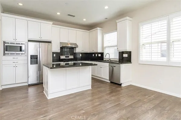 a kitchen with granite countertop white cabinets and white appliances