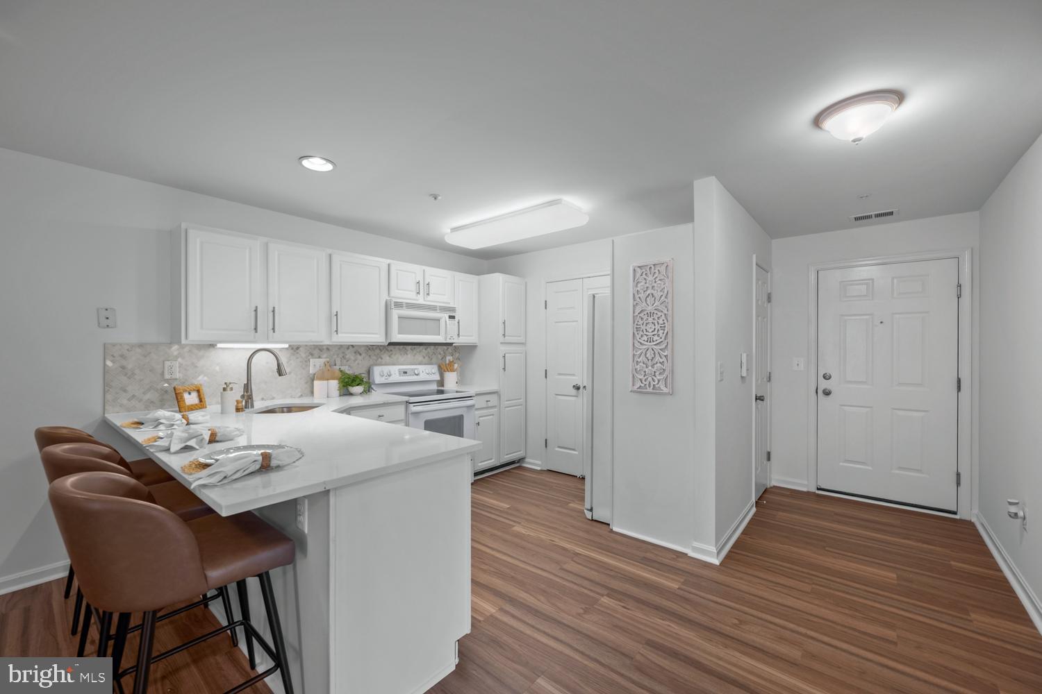 2011 Rudy Serra Drive, Unit 1C Eldersburg, MD 21784 - Photo 12 of 36 a kitchen with a table chairs refrigerator and cabinets