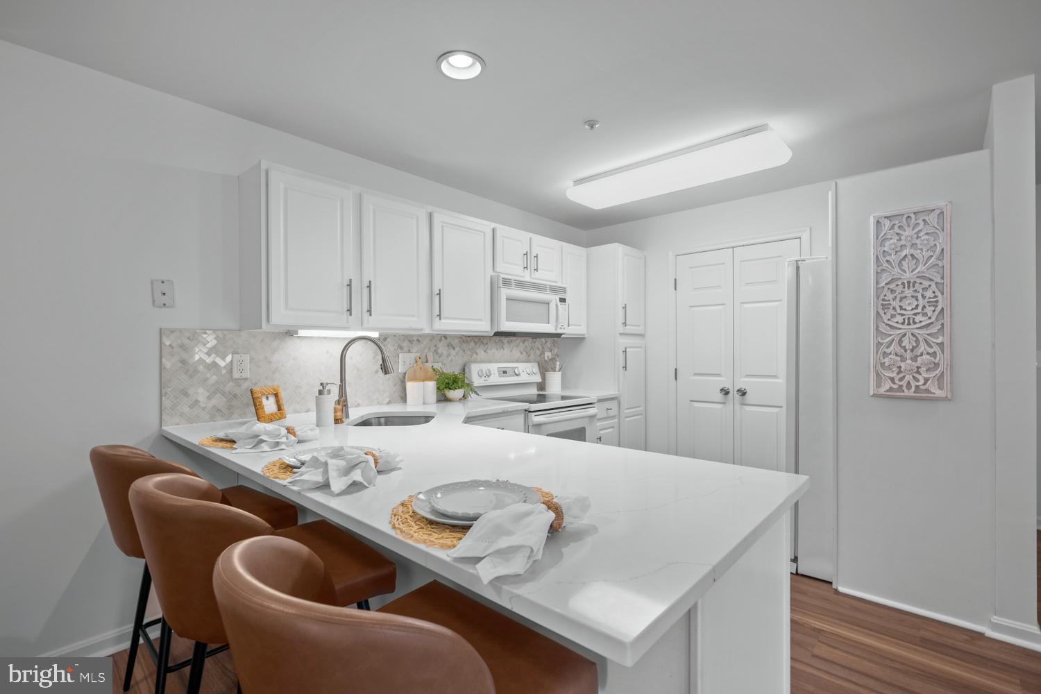 2011 Rudy Serra Drive, Unit 1C Eldersburg, MD 21784 - Photo 13 of 36 a kitchen with stainless steel appliances granite countertop a sink a stove a dining table and chairs