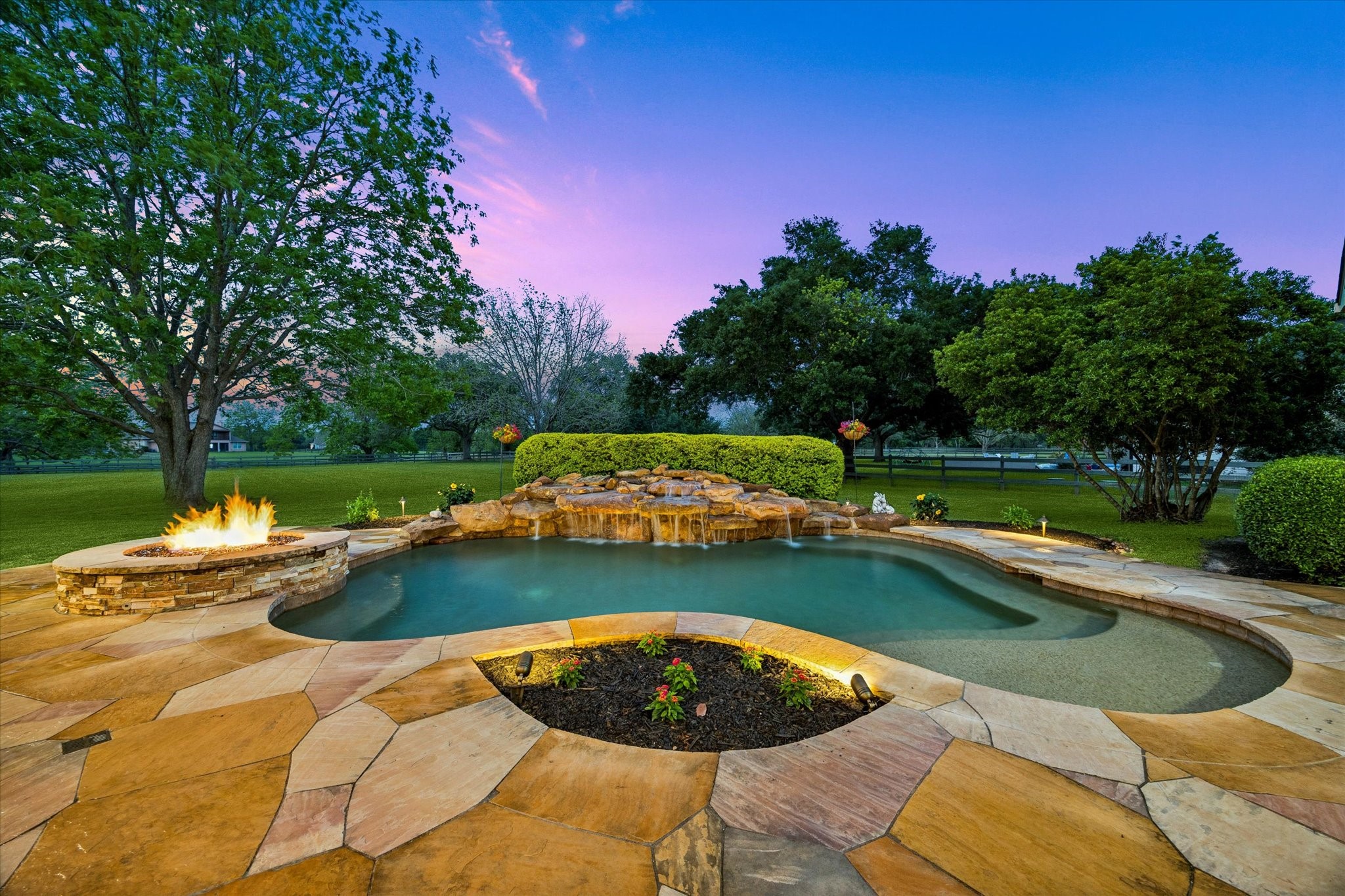 32102 Fulbrook Commons Fulshear, TX 77441 - Photo 35 of 50 A custom pool with cascading waterfall and integrated fire feature serves as the stunning centerpiece of this beautifully landscaped outdoor oasis.