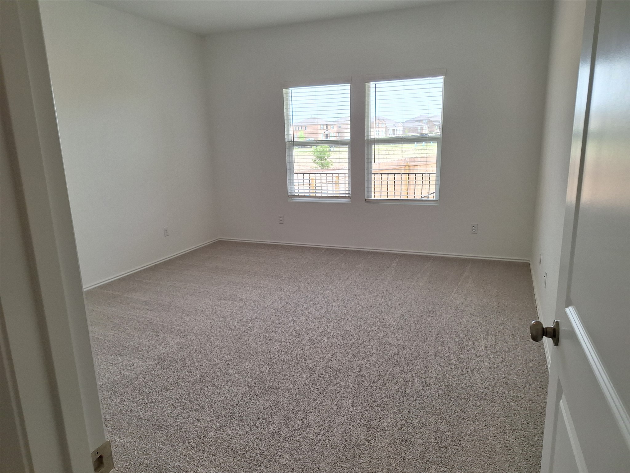 18001 Prairie Falcon Way Pflugerville, TX 78660 - Photo 14 of 38 Spacious room featuring neutral carpet flooring, white painted walls, two large windows with blinds, and white trim molding