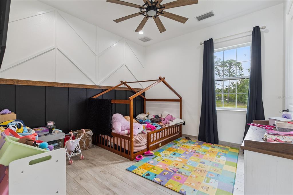 345 Cypress Isles Road Osteen, FL 32764 - Photo 22 of 41 a bedroom with a bed and a wooden floor