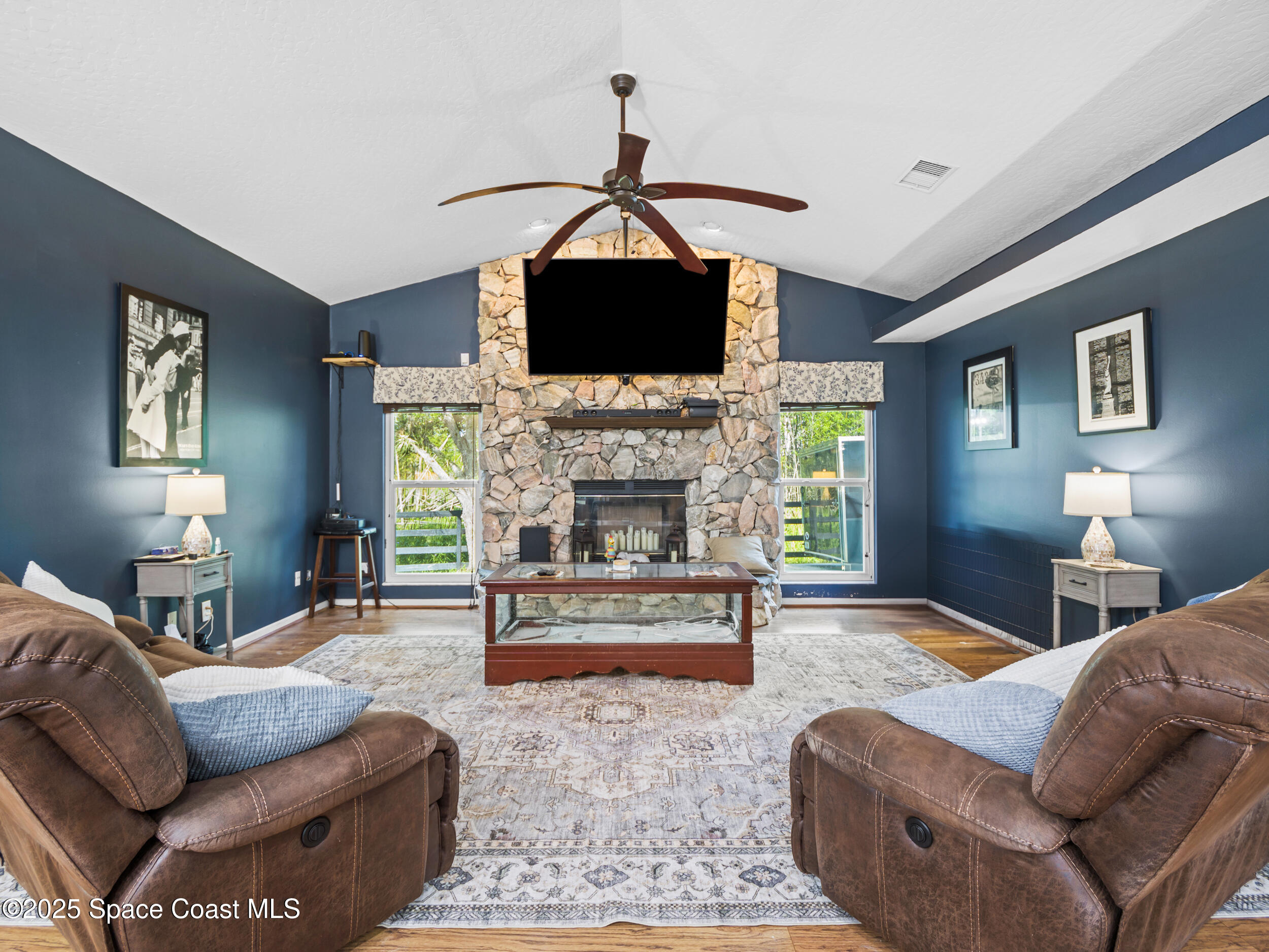 239 Deer Run Road Palm Bay, FL 32909 - Photo 15 of 43 a living room with furniture a flat screen tv and a fireplace
