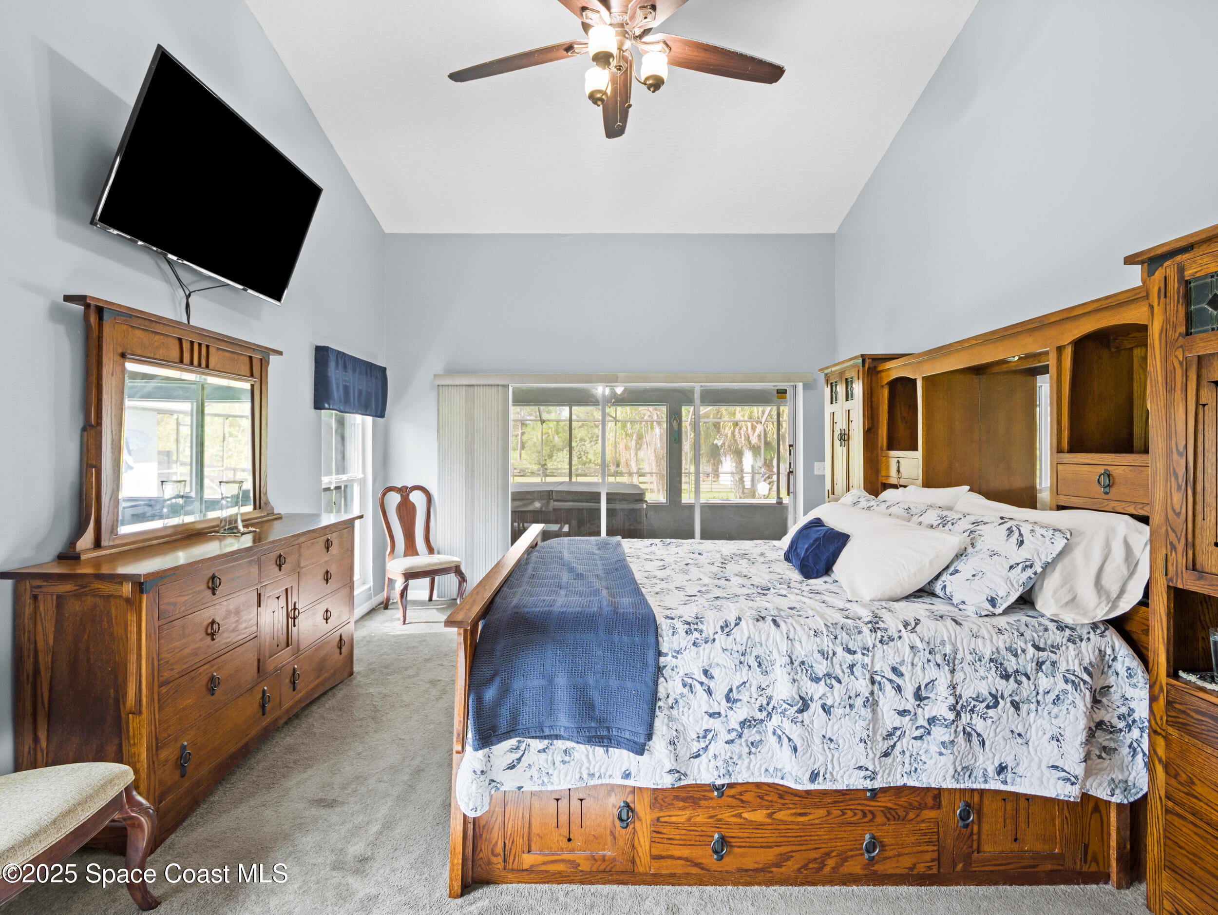 239 Deer Run Road Palm Bay, FL 32909 - Photo 19 of 43 a bedroom with a large bed and a flat tv screen