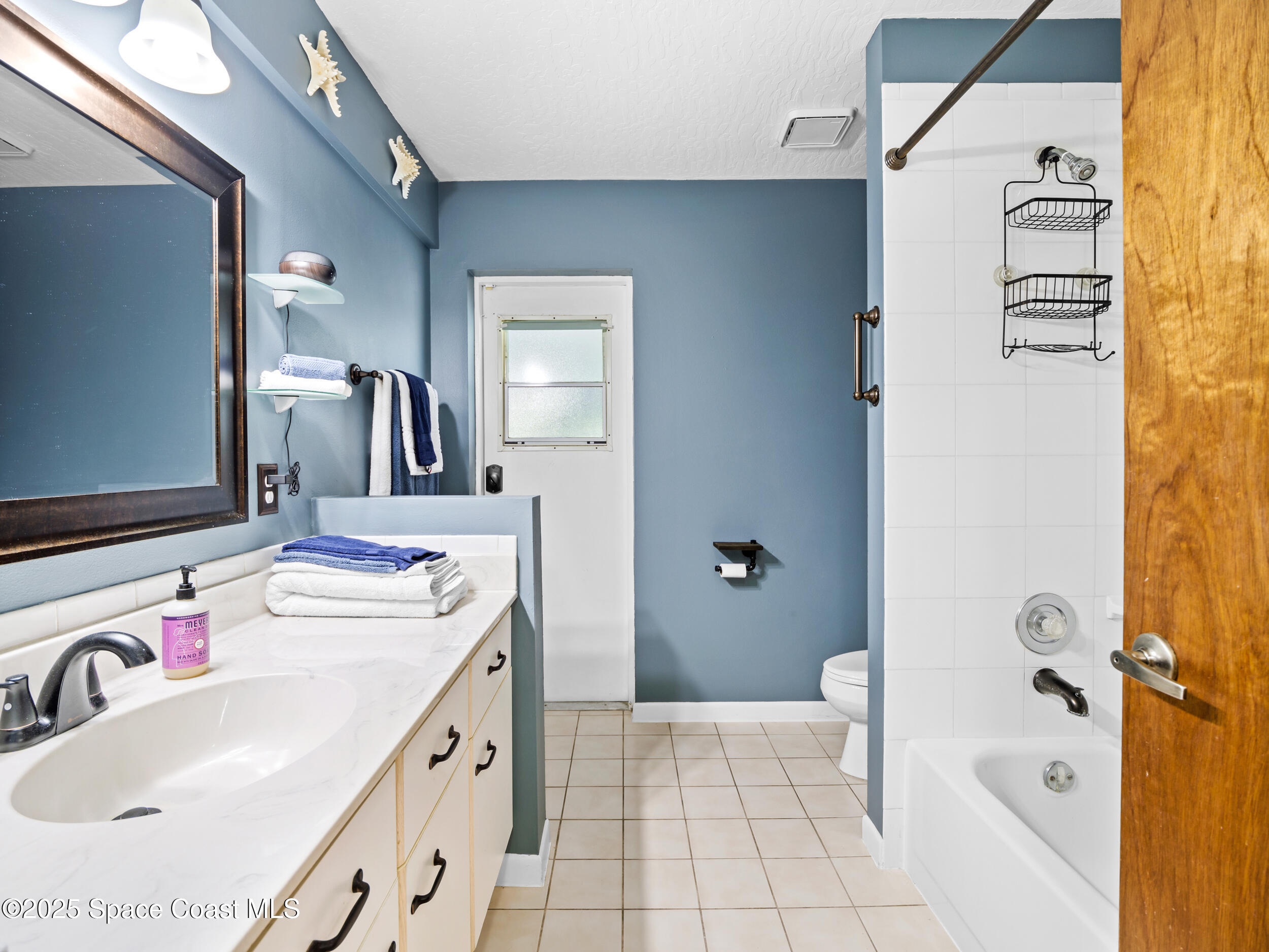 239 Deer Run Road Palm Bay, FL 32909 - Photo 24 of 43 a bathroom with a sink a mirror and a bathtub