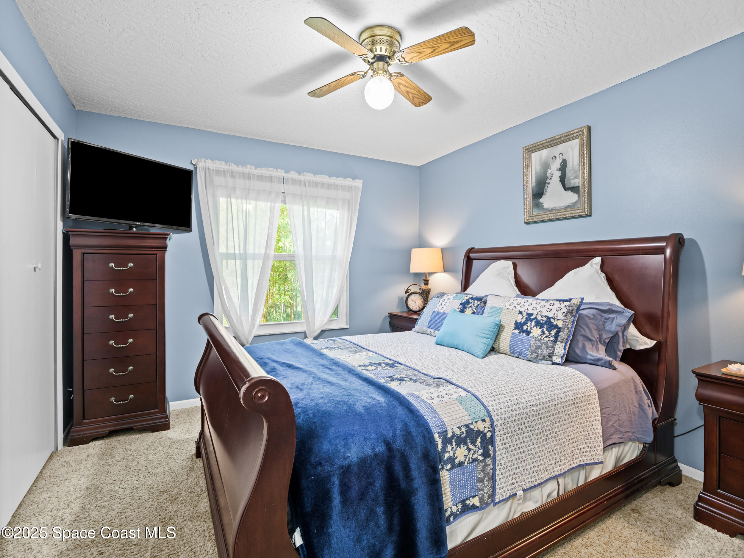239 Deer Run Road Palm Bay, FL 32909 - Photo 26 of 43 a bedroom with a bed and a flat screen tv