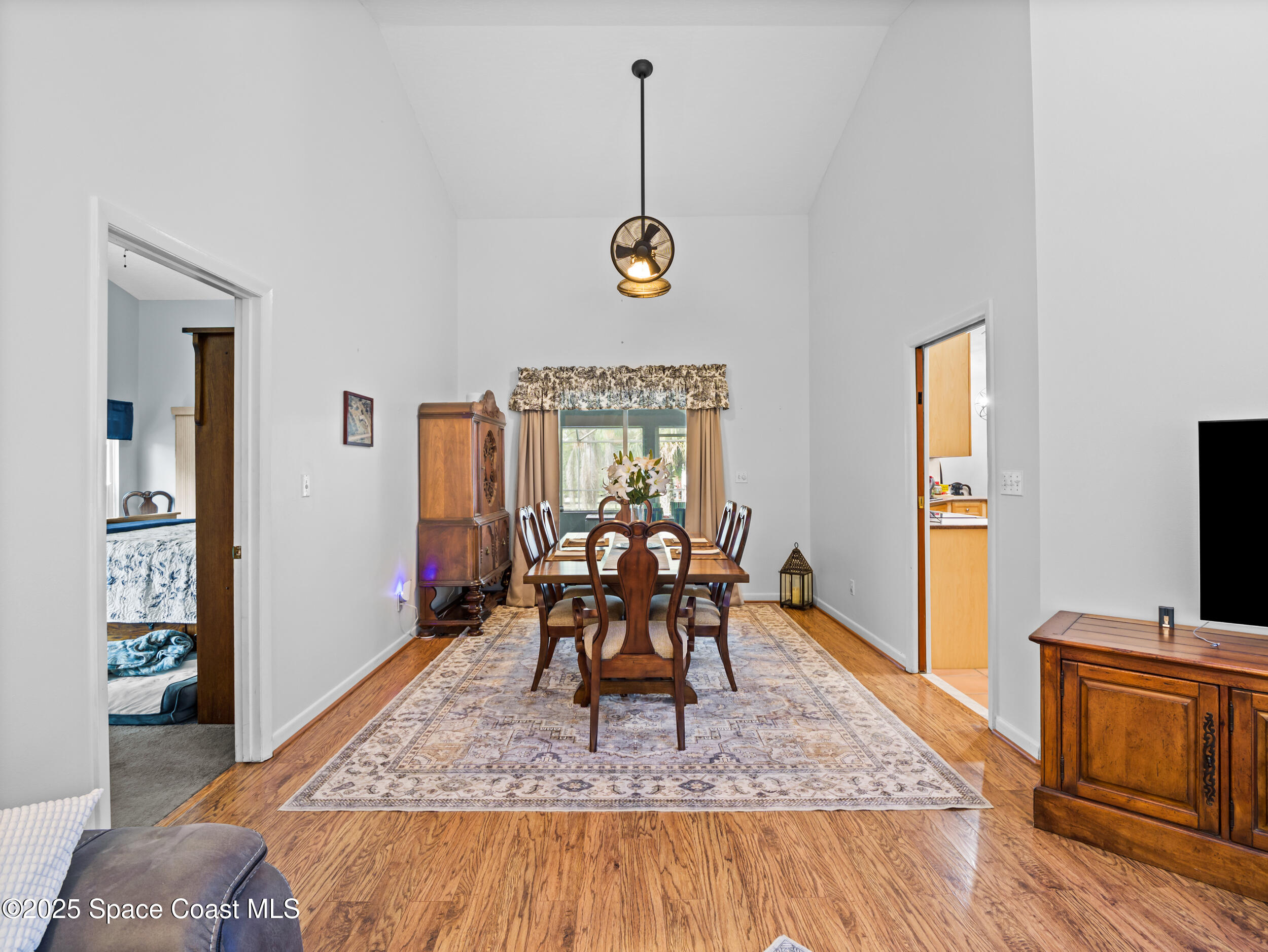 239 Deer Run Road Palm Bay, FL 32909 - Photo 8 of 43 a dining room with wooden floor a chandelier a wooden table and chairs