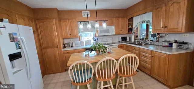 a kitchen with stainless steel appliances granite countertop a table chairs in it and wooden floors