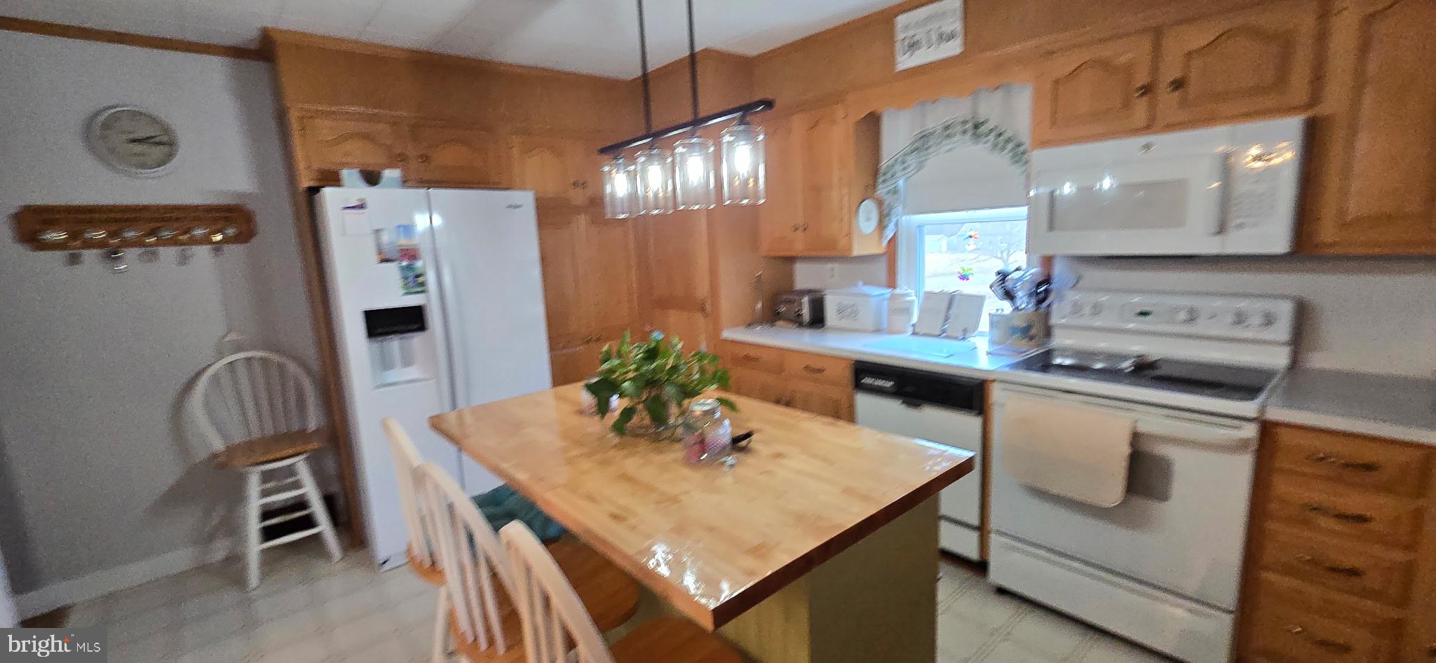 1447 Crottlestown Road Chambersburg, PA 17202 - Photo 7 of 16 a kitchen with stainless steel appliances granite countertop a table chairs in it and wooden floors
