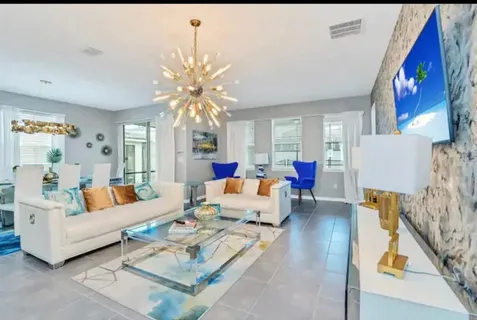 a view of a dining room with furniture a chandelier and wooden floor