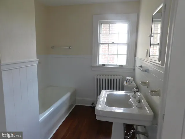 a bathroom with a sink a bathtub and a window