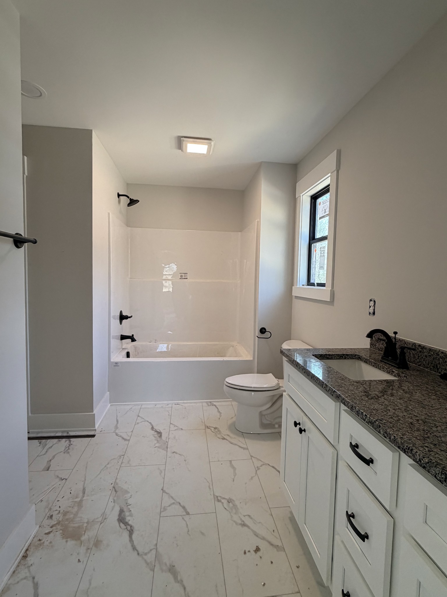 1007 Mt Olive Road Westmoreland, TN 37186 - Photo 22 of 31 a bathroom with a granite countertop sink a toilet and a bathtub