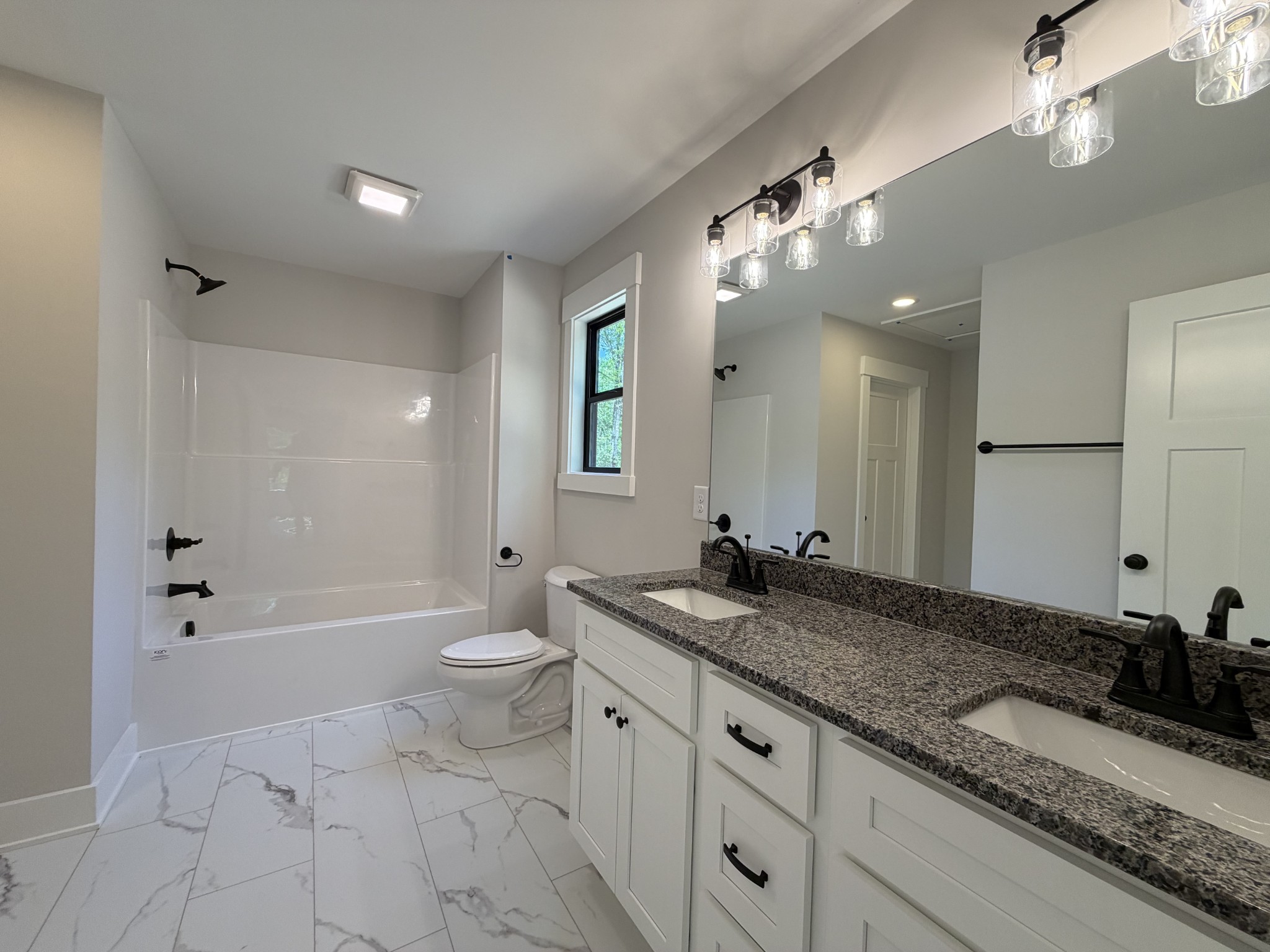 1007 Mt Olive Road Westmoreland, TN 37186 - Photo 28 of 31 a bathroom with a granite countertop sink a toilet a large mirror and shower