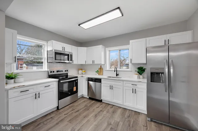 a kitchen with white cabinets stainless steel appliances and a window