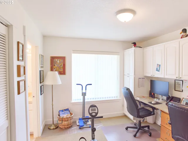 a view of a workspace with furniture and a window