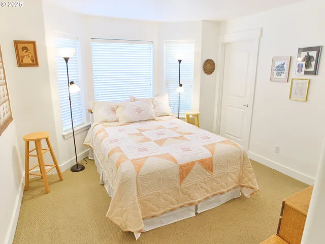 a bedroom with a bed and painting on the wall