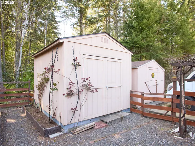 a backyard of a house with wooden chairs and iron fence