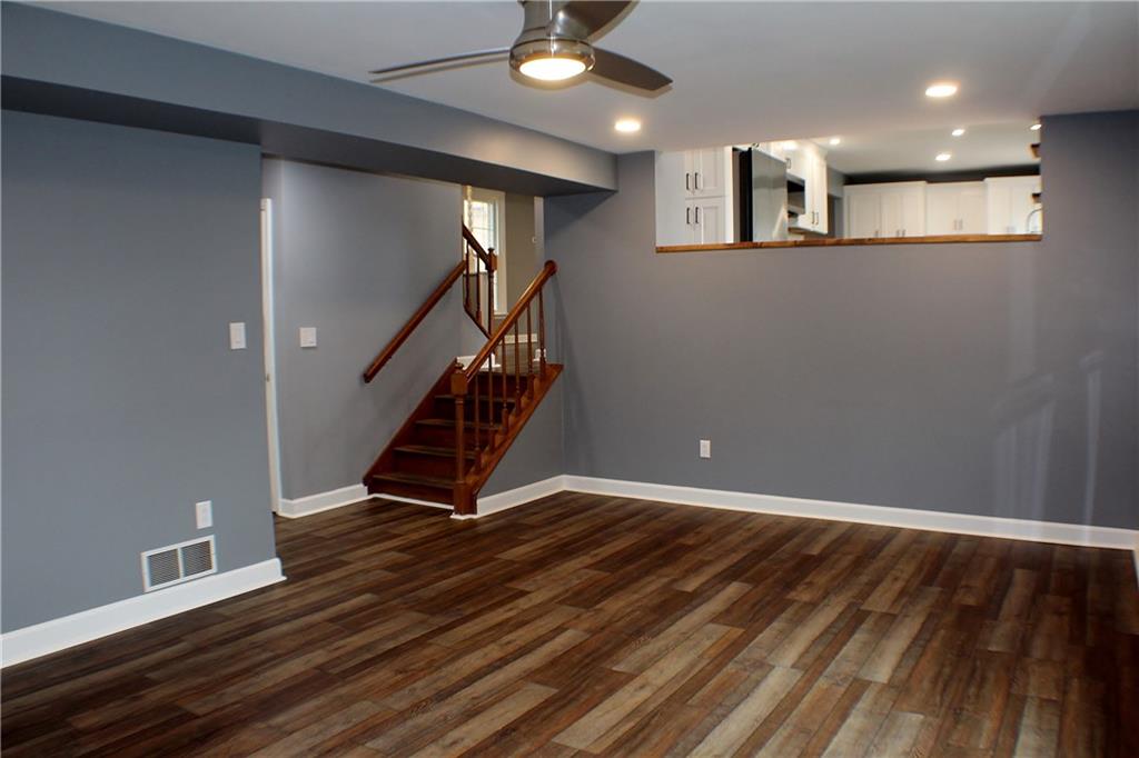 9462 Peebles Road Allison Park, PA 15101 - Photo 16 of 50 a view of an empty room with wooden floor stairs and a chandelier fan