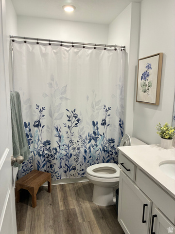 673 West 1920 South, Unit 1063 Provo, UT 84601 - Photo 13 of 15 Bathroom featuring wood-finish flooring, a white vanity with a light-toned countertop, a toilet, and a recessed ceiling light
