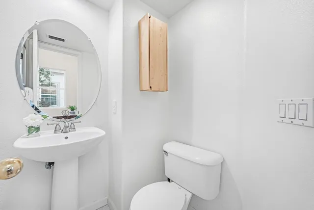 a bathroom with a toilet sink and mirror