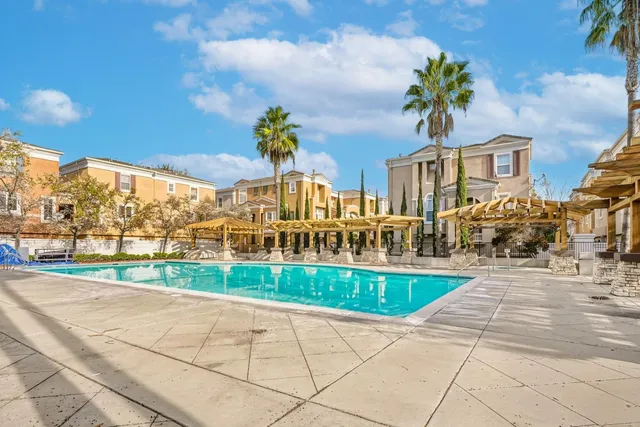 a view of a building with a big yard and large trees