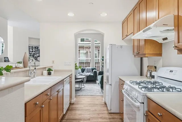 a kitchen with kitchen island granite countertop a sink stove and cabinets