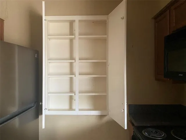 a room with walk in closet and empty racks