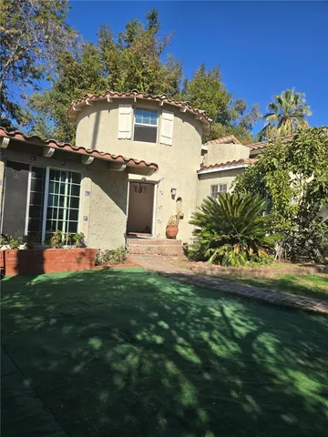 a front view of a house with a garden