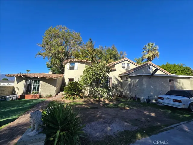 a view of a house with a yard and potted plants