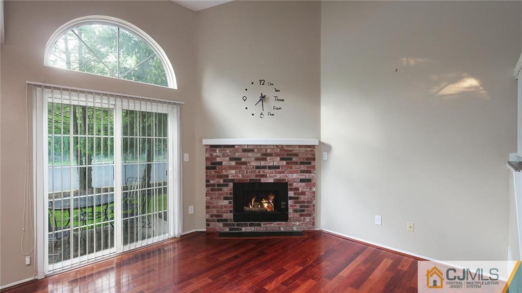 201 Nebula Road Piscataway, NJ 08854 - Photo 8 of 27 an empty room with wooden floor a fireplace and a large window