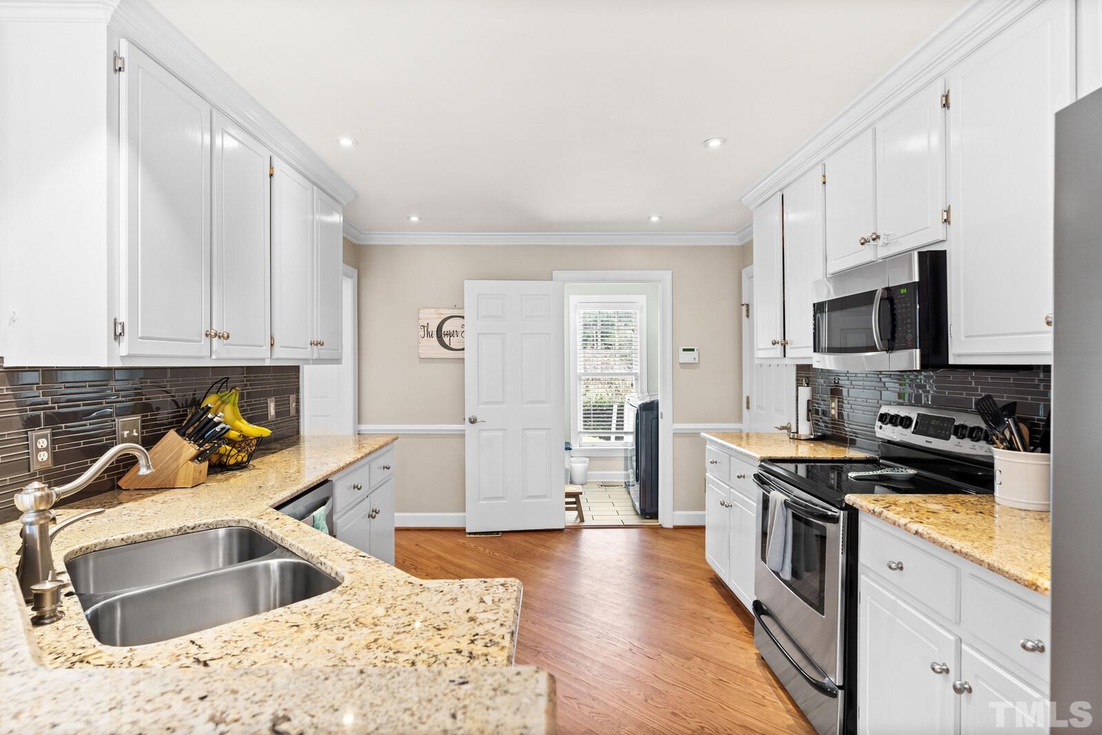 9100 Dawnshire Road Raleigh, NC 27615 - Photo 10 of 30 a kitchen with a sink stove top oven and refrigerator