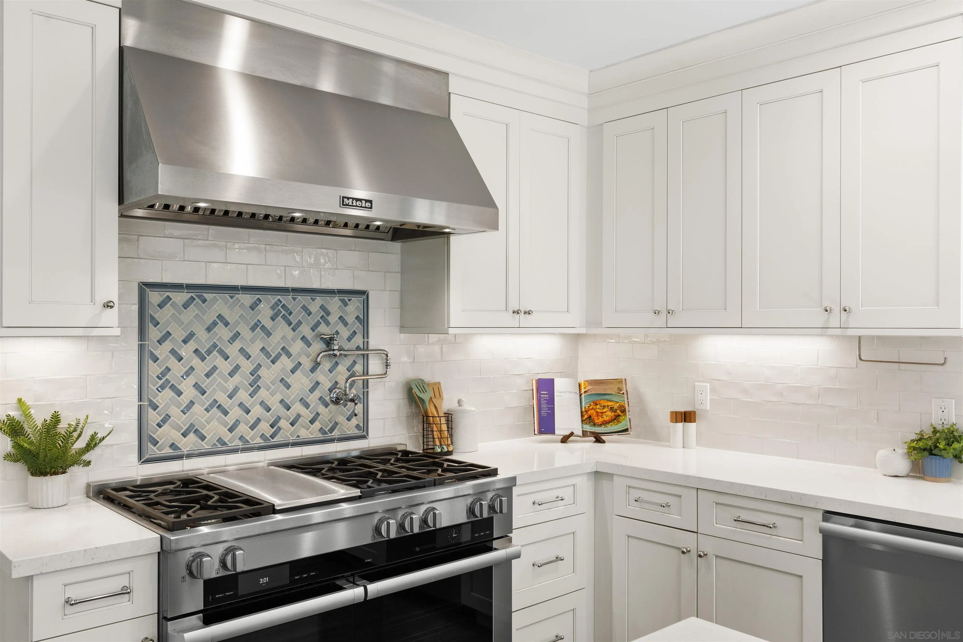 708 Silver Street La Jolla, CA 92037 - Photo 16 of 44 a kitchen with stainless steel appliances granite countertop a stove and a white cabinets