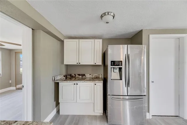 a kitchen with a refrigerator sink and cabinets