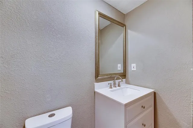 a bathroom with a toilet a sink and mirror