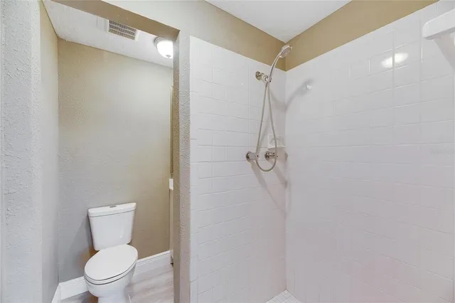 a bathroom with a toilet and a shower