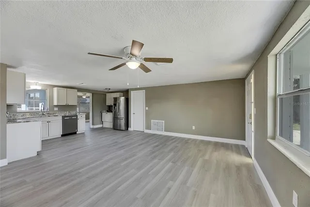 a view of a livingroom with a ceiling fan hardwood floor and a ceiling fan