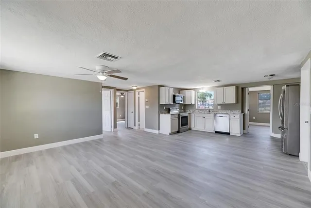 a view of a kitchen with furniture and wooden floor