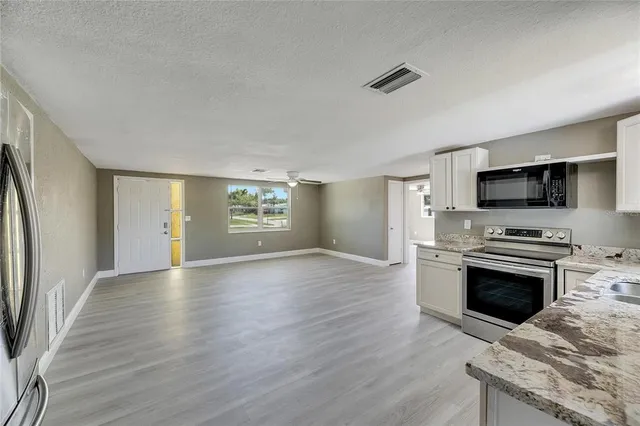 a view of kitchen with sink microwave and refrigerator