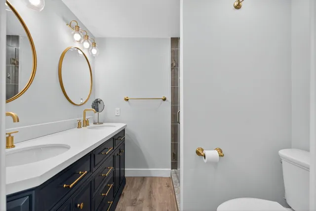 a bathroom with a granite countertop sink mirror and toilet