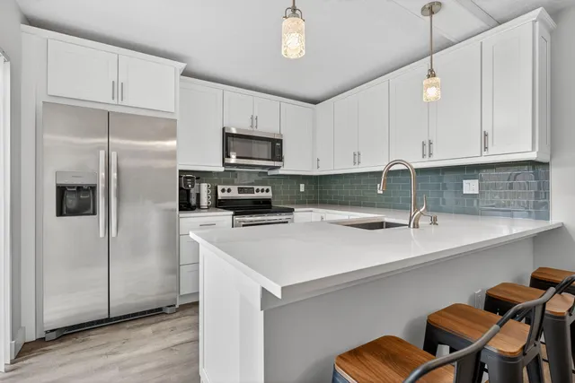 a kitchen with stainless steel appliances cabinets a sink and a refrigerator