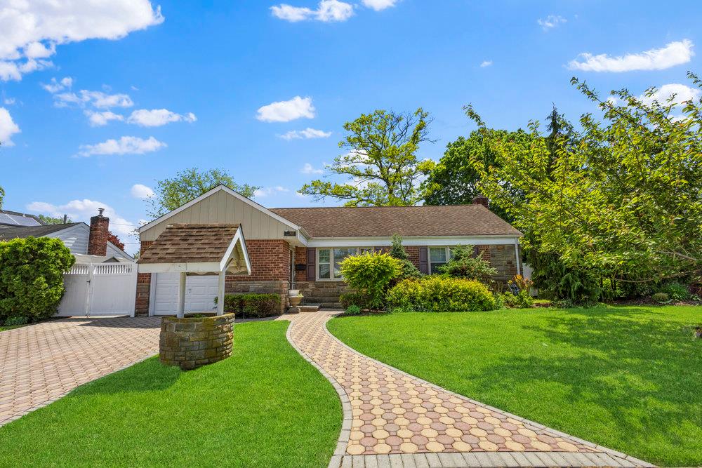 View of front of home featuring brick siding, a gate, and driveway