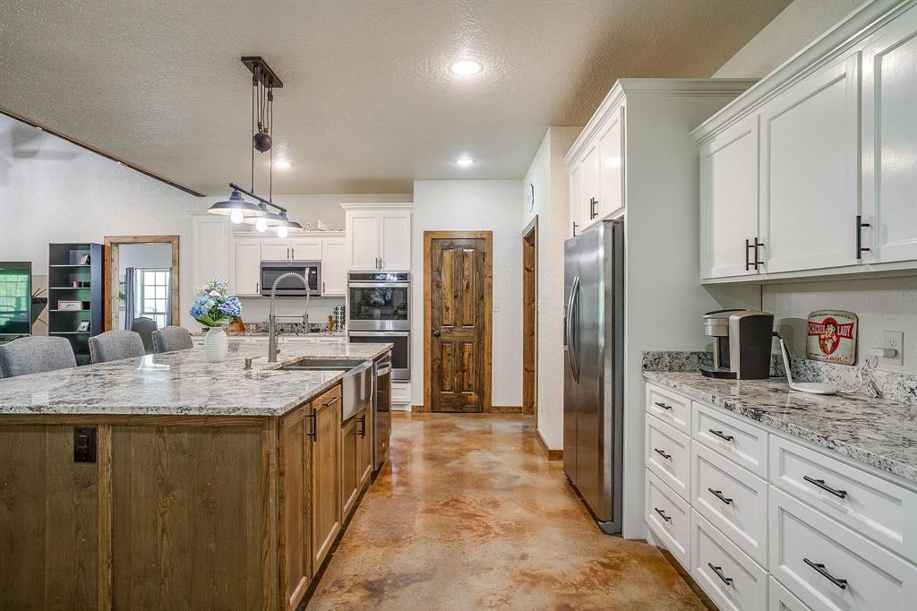 201 Curry Road Waxahachie, TX 75167 - Photo 11 of 40 a kitchen with kitchen island granite countertop a sink stove and refrigerator