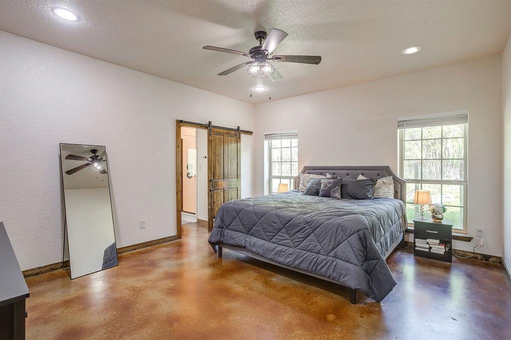 201 Curry Road Waxahachie, TX 75167 - Photo 16 of 40 a spacious bedroom with a large bed and a chandelier