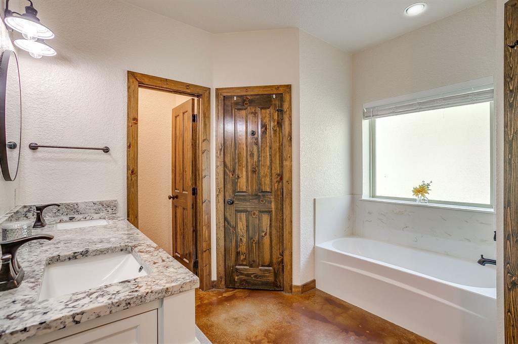 201 Curry Road Waxahachie, TX 75167 - Photo 18 of 40 a bathroom with a granite countertop sink and a bathtub