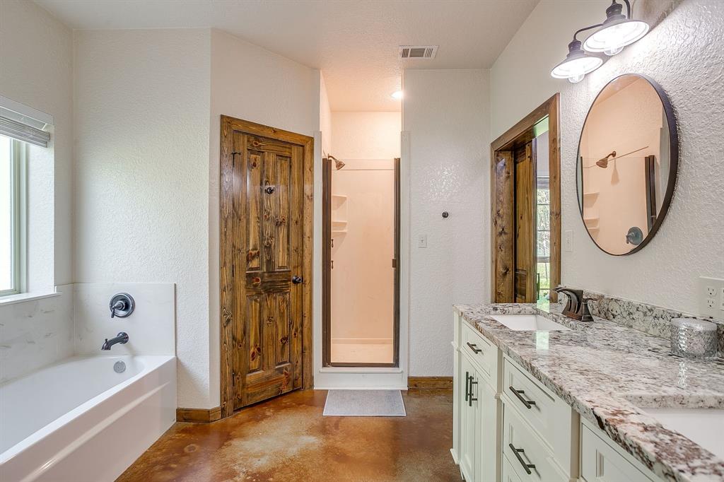 201 Curry Road Waxahachie, TX 75167 - Photo 19 of 40 a bathroom with a granite countertop tub sink and mirror