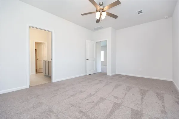 an empty room with closet and a chandelier fan